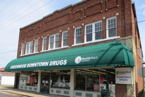 Green convex storefront awning with graphics